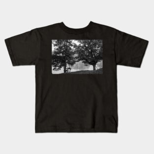 Black and white Two oak trees on river edge in early  morning fog Kids T-Shirt